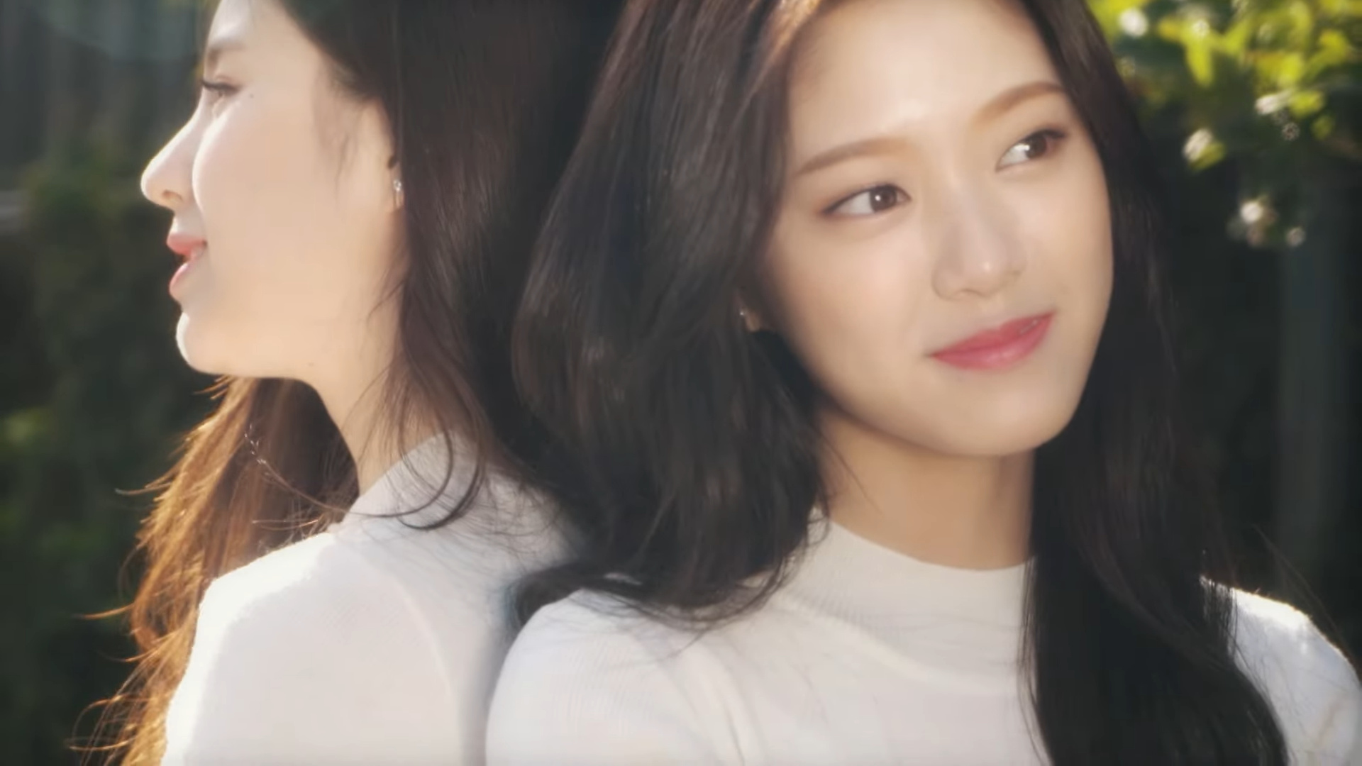 Heejin and Hyunjin sitting back to back.